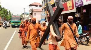 Carrying a large cross but wearing Hindu monks attire. Why?